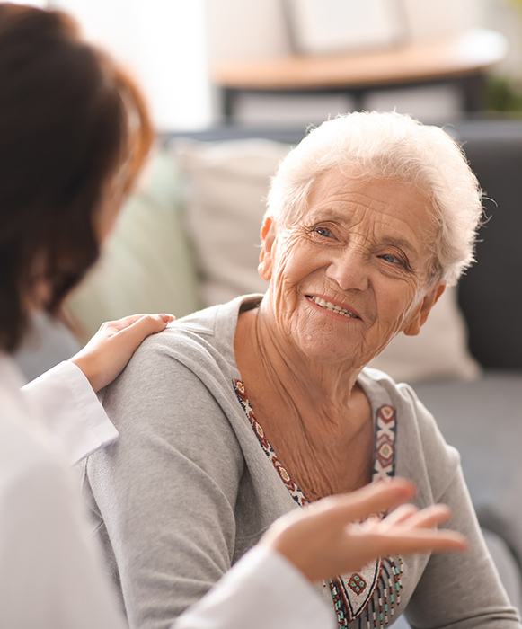 Young doctor visiting elderly woman at home